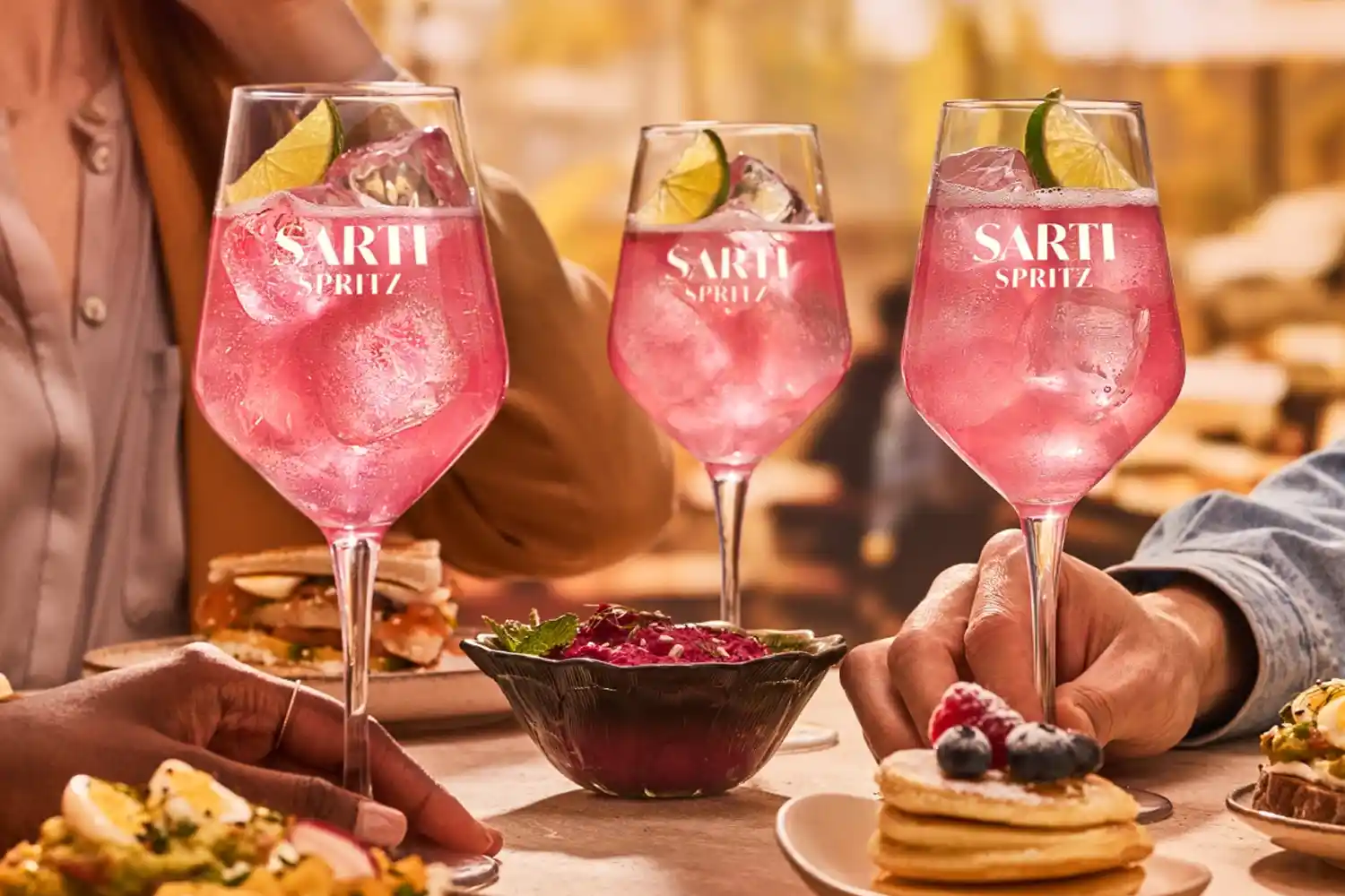 drei gläser sarti spritz mit antipasti